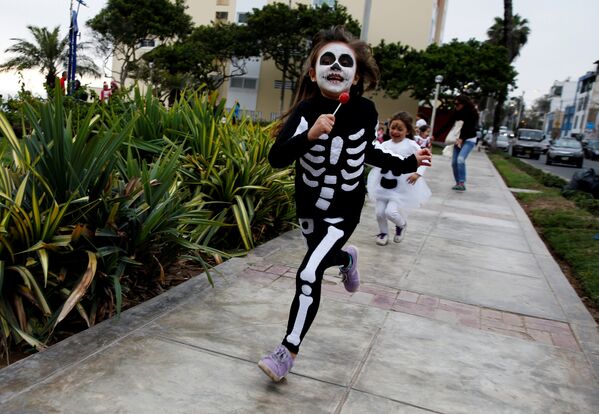 По улицам города Лима в Перу во время празднования Хэллоуина бегали дети в устрашающих нарядах - Sputnik Молдова