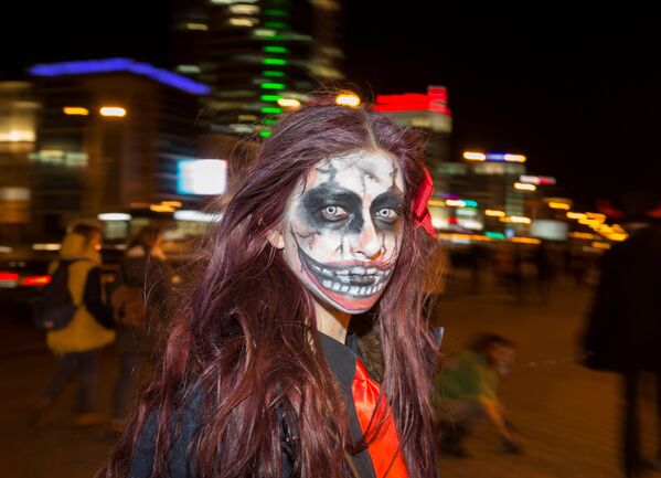 Девушка, лицо которой косметика превратила в маску зомби, отмечает Хэллоуин в Минске, Беларусь - Sputnik Молдова