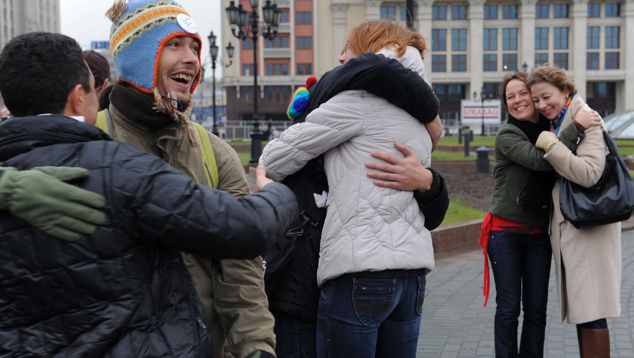 Обними россию. Люди обнимаются на улице. День объятий. Дружелюбные люди в России. Люди на празднике обнимаются.