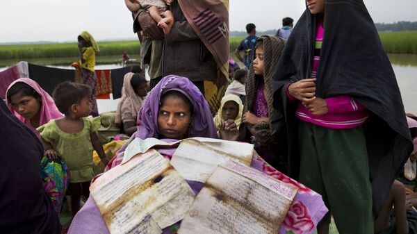 Женщина-рохинджа, бегущая из Мьянмы в Бангладеш, сушит свои документы на границе  - Sputnik Moldova-România