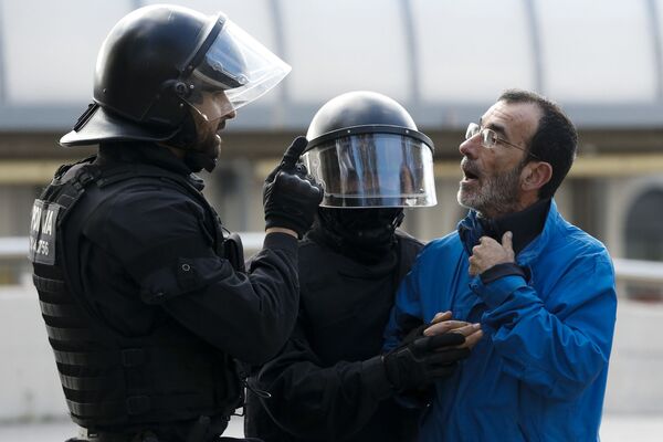 Полицейские из Mossos d'Esquadra беседуют с одним из пикетчиков, которые блокирует улицу на севере Барселоны - Sputnik Молдова