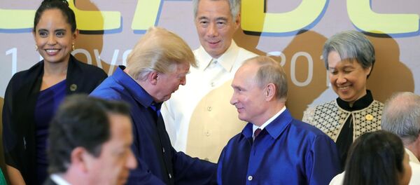 Президент РФ Владимир Путин и президент США Дональд Трамп (слева на втором плане) на церемонии совместного фотографирования в национальной вьетнамской одежде лидеров экономик стран Азиатско-Тихоокеанского экономического сотрудничества (АТЭС) во Вьетнаме. - Sputnik Moldova-România