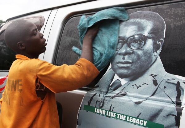 Мальчик моет микроавтобус с изображением президента Зимбабве Роберта Мугабе на стекле ф Хараре - Sputnik Молдова