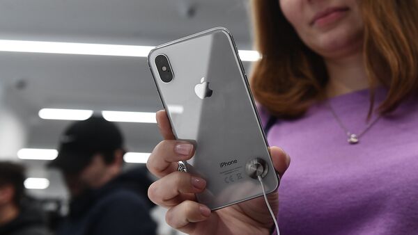 A buyer examines a new smartphone iPhone X in re:Store mobile equipment store on Tverskaya Street in Moscow - Sputnik Moldova-România