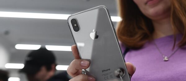 A buyer examines a new smartphone iPhone X in re:Store mobile equipment store on Tverskaya Street in Moscow - Sputnik Moldova-România