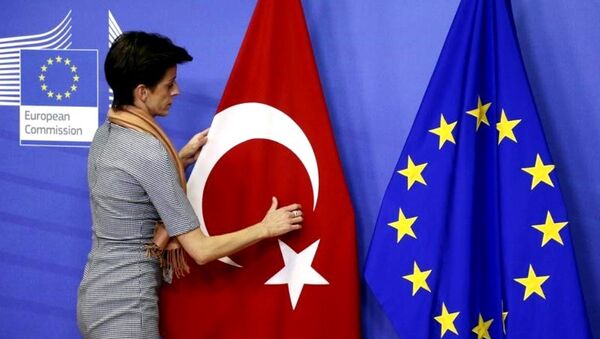 A woman adjusts the Turkish flag next to the European Union flag before the arrival of Turkish Prime Minister Ahmet Davutoglu (unseen) at the EU Commission headquarters in Brussels January 15, 2015. - Sputnik Moldova-România