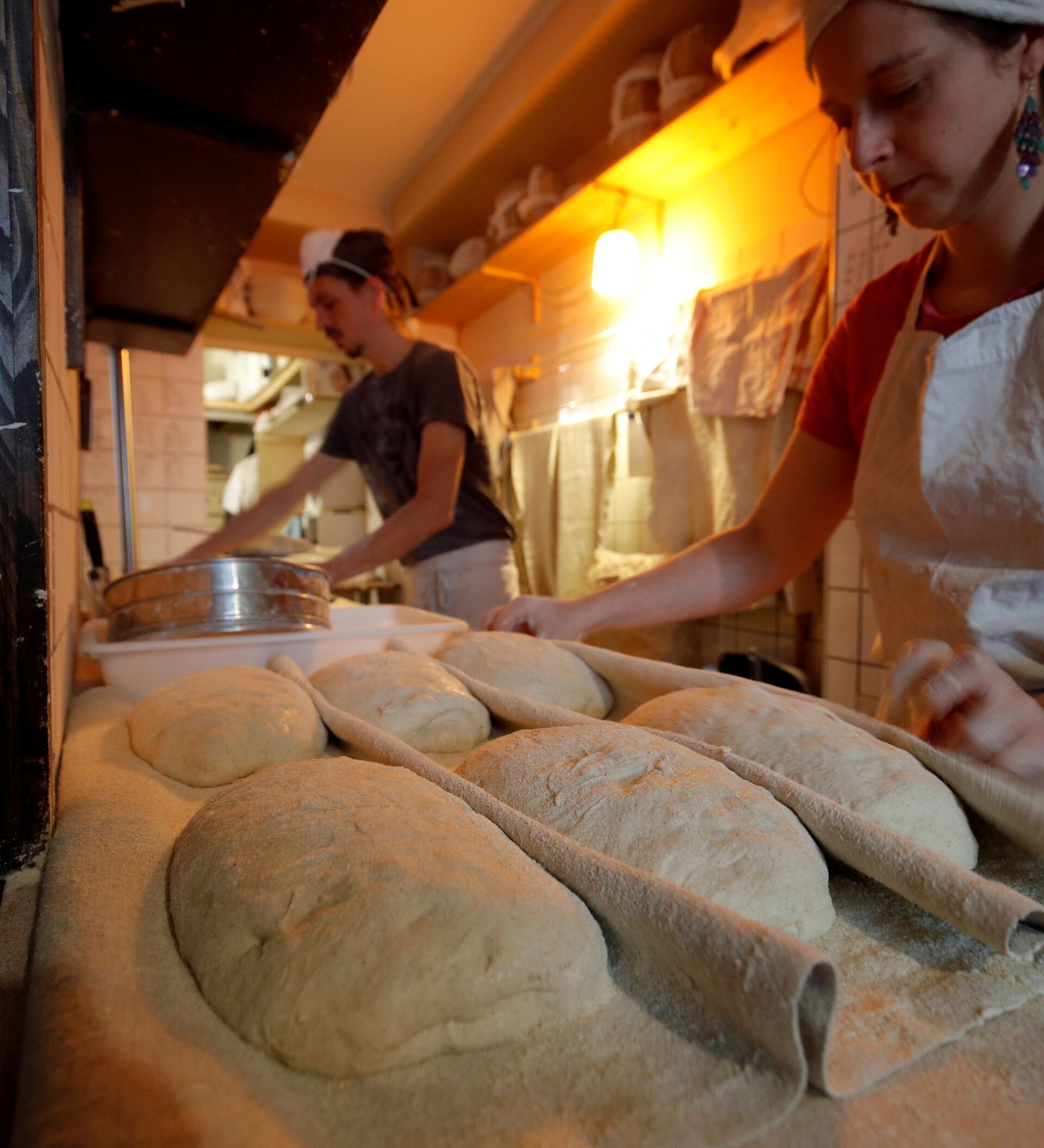 Видео печь хлеб. Хлеб в печи. Пекарня пекут хлеб. Пекарь печет хлеб. Молдавская печь для хлеба.