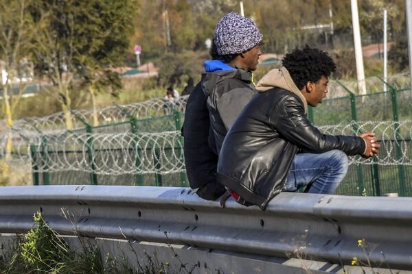 Migranți pe centura orașului Calais, Franța Migranți pe centura orașului Calais, Franța - Sputnik Moldova-România