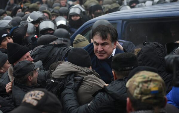 Ликующие сторонники Саакашвили смогли добиться его освобождения и криками и рукоплесканиями встретили своего лидера, который выбрался из полицейского микроавтобуса - Sputnik Молдова
