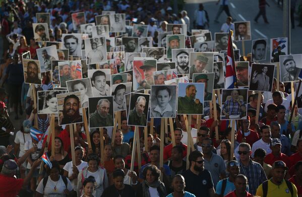 Люди с изображениями Фиделя Кастро во время марша, посвященного первой годовщине погребения бывшего кубинского лидера в Сантьяго - Sputnik Молдова