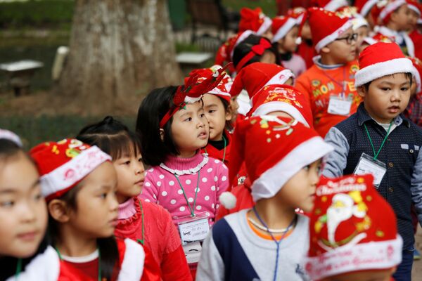 Дети в костюмах Санта-Клаусов у озера Хоанкьем в Ханое, Вьетнам - Sputnik Молдова
