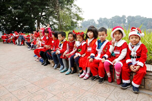 Дети в костюмах Санта-Клаусов у озера Хоанкьем в Ханое, Вьетнам - Sputnik Молдова