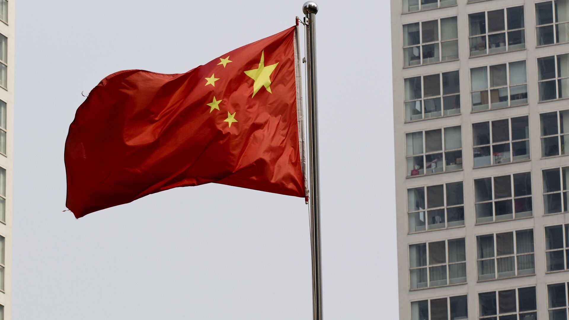 A Chinese national flag flutters in the wind in between a high-rise residential and office complex in Beijing, China. (File) - Sputnik Moldova, 1920, 07.05.2022