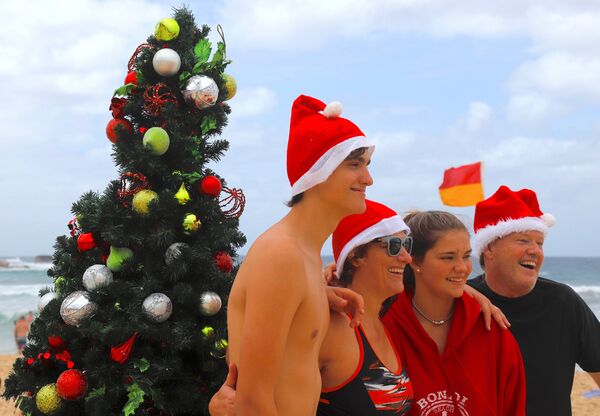 Семья фотографируется на фоне рождественского дерева на пляже Бонди в Сиднее, Австралия - Sputnik Молдова