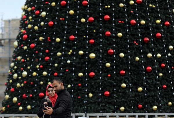 Люди делают селфи у рождественской елки в Вифлееме - Sputnik Молдова