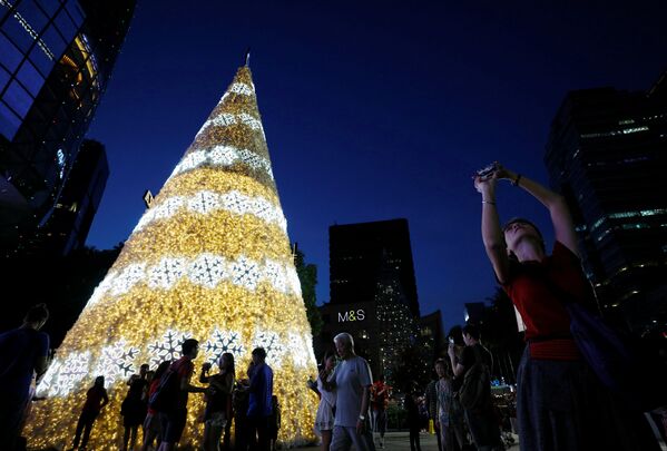 Люди фотографируются у рождественской елки в Сингапуре - Sputnik Молдова