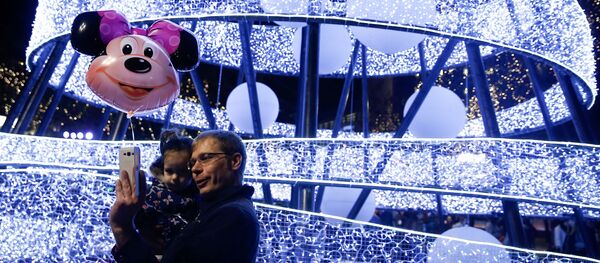 Мужчина делает селфи с ребенком на фоне рождественской иллюминации в Афинах, Греция - Sputnik Молдова