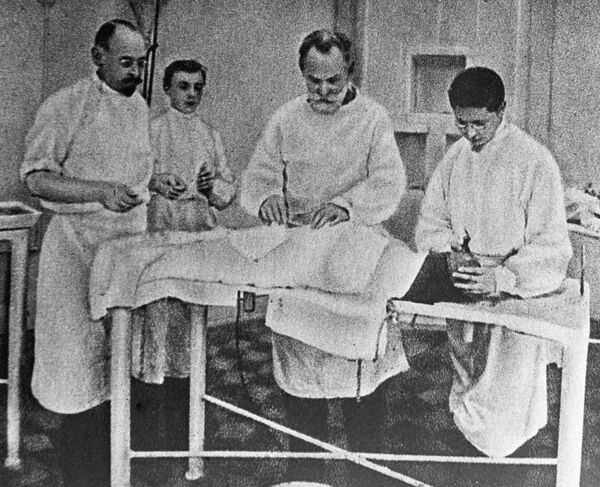 Академик Иван Павлов (второй справа) оперирует собаку. 17 сентября 1903 года - Sputnik Молдова