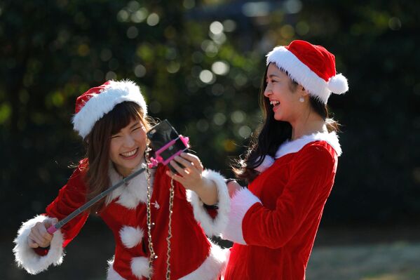 Девушки в костюмах Санта-Клаусов фотографируются во время благотворительного забега Tokyo Santa Run в Чибе - Sputnik Молдова