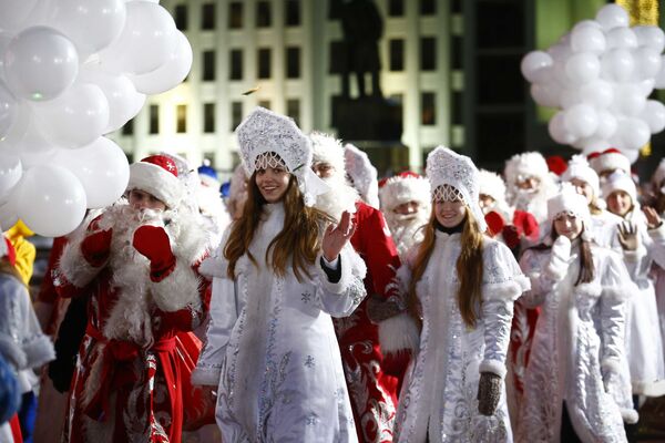 Люди в костюмах Снегурочек и Дед Морозов во время парада в Минске - Sputnik Молдова