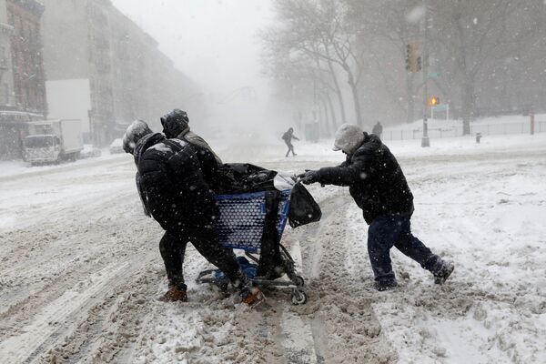 Bărbați ducând un coș cu cumpărături pe strada 125 din Manhattan în timpul furtunii de zăpadă Grayson, New York, SUA - Sputnik Moldova
