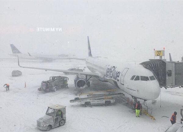 Персонал работает рядом с самолетом, припаркованным на стоянке в международном аэропорту Джона Ф. Кеннеди во время снежной бури, район Квинс, Нью-Йорк, США - Sputnik Молдова