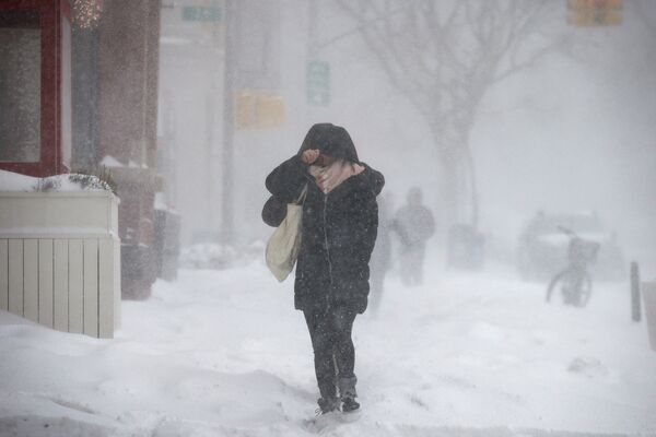 Люди идут по заснеженным улицам Бруклина при сильном ветре во время шторма Грейсон в Нью-Йорке, США - Sputnik Молдова