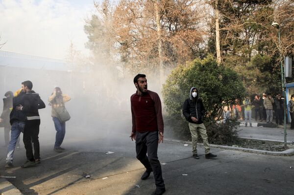 Iran, university students attend a protest inside Tehran University while a smoke grenade is thrown by anti-riot Iranian police, in Tehran, Iran, Saturday, Dec. 30, 2017 Iran, university students attend a protest inside Tehran University while a smoke grenade is thrown by anti-riot Iranian police, in Tehran, Iran, Saturday, Dec. 30, 2017 - Sputnik Moldova-România
