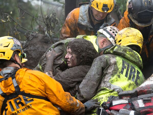 Спасатели достают женщину из под завалов ее дома, который был разрушен оползнем в Монтесито, Калифорния - Sputnik Молдова