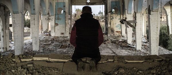 Житель одной из деревень в провинции Эль-Хасаке молится в храме Святого Георгия, разрушенного боевиками ИГ, 8 декабря 2015 года - Sputnik Moldova