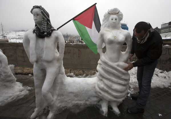 Палестинец во время создания снеговиков в Иерусалиме - Sputnik Молдова