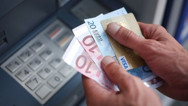 A man takes out Euro banknotes from an automated teller machine (ATM) - Sputnik Moldova-România
