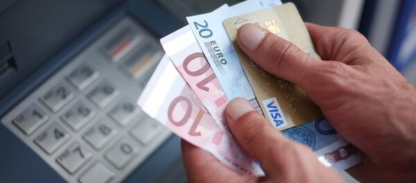 A man takes out Euro banknotes from an automated teller machine (ATM) - Sputnik Moldova-România