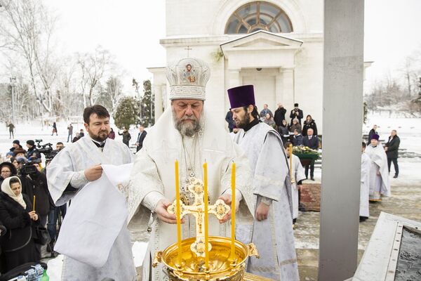 Митрополит Владимир окунает крест в сосуд с водой - Sputnik Молдова