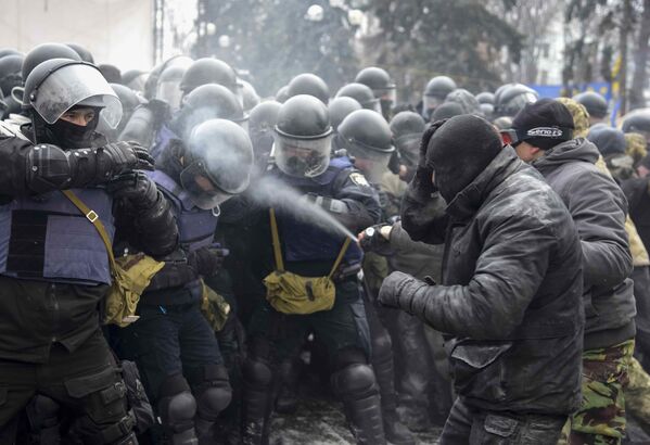 Мужчина поливает слезоточивым газом сотрудников ОМОНа в лагере сторонников Михаила Саакашвили у здания парламента в Киеве - Sputnik Молдова