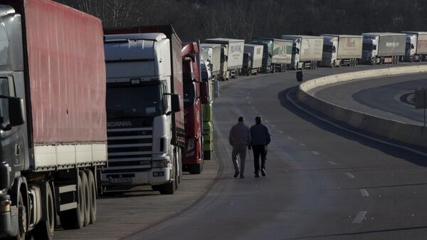 Truck drivers walk next to parked trucks as protesting farmers (not pictured) block the road leading to the border station of Greece with Bulgaria during a demonstration against planned pension reforms near the Greek village of Promachonas. - Sputnik Moldova-România