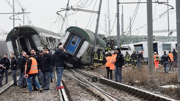 Rescue workers and police officers stand near derailed trains in Pioltello, on the outskirts of Milan, Italy, January 25, 2018 - Sputnik Moldova