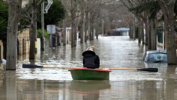 Местные жители переправляются на лодке на одной из затопленной улице в Париже - Sputnik Молдова