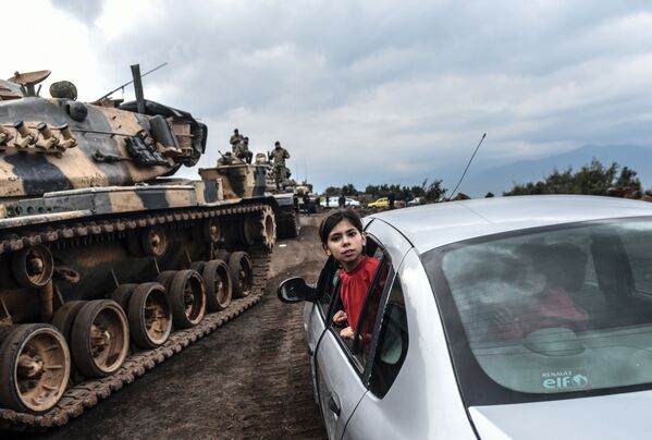 Турецкая девочка наблюдает из окна автомобиля, как танки и солдаты турецкой армии собираются у сирийской границы в городе Хасса - Sputnik Молдова