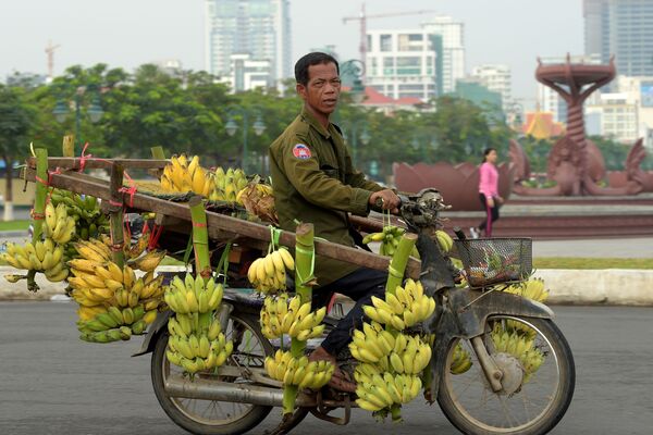 Камбоджиец на мотоцикле, груженном бананами, в Пномпене - Sputnik Молдова