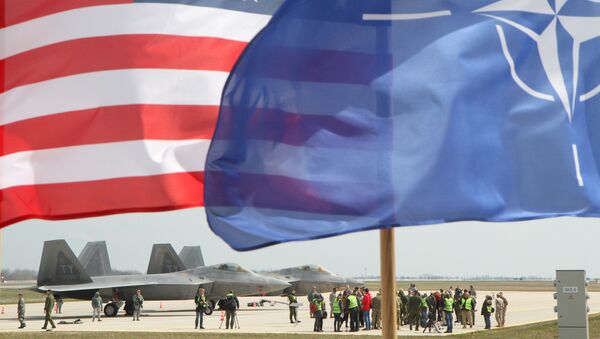 The US and The NATO flag flie in front of two US Air Force F-22 Raptor fighter aircrafts at the Air Base of the Lithuanian Armed Forces in Šiauliai, Lithuania, on April 27, 2016. - Sputnik Moldova