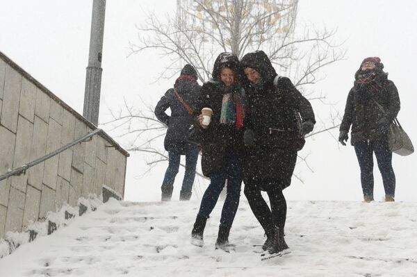 Девушки на ступеньках подземного перехода во время снегопада в Москве - Sputnik Молдова
