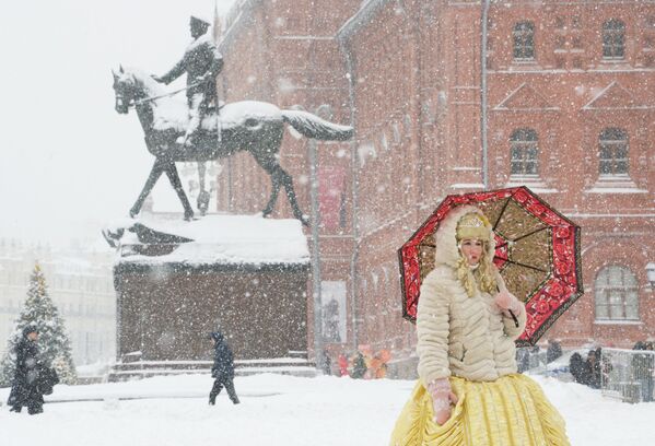 Женщина с зонтом на Манежной площади во время снегопада в Москве - Sputnik Молдова