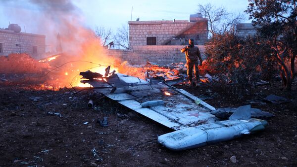 A picture taken on February 3, 2018, shows a Rebel fighter taking a picture of a downed Sukhoi-25 fighter jet in Syria's northwest province of Idlib - Sputnik Moldova-România