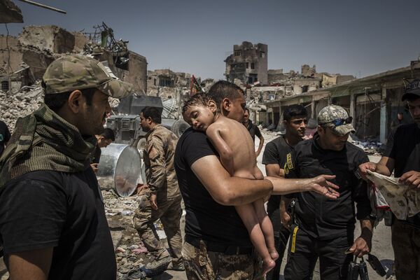 Снимок The Battle for Mosul - Young Boy Is Cared for by Iraqi Special Forces Soldiers фотографа Ivor Prickett, номинант на победу в категории World Press Photo Of The Year фотоконкурса World Press Photo 2018 - Sputnik Молдова