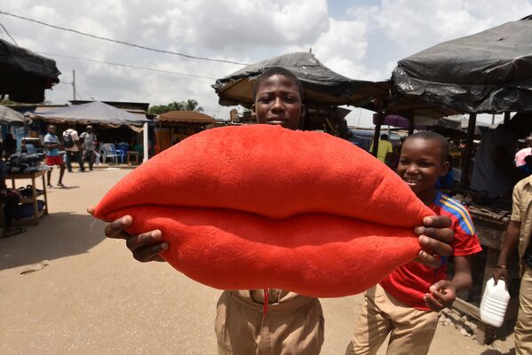 Дети с подушкой в виде красных губ на окраине Йопугона, Кот-д'Ивуар - Sputnik Молдова
