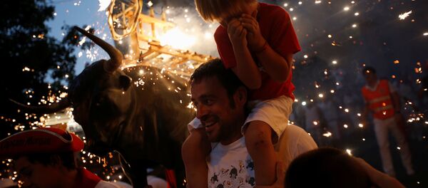 The Fire Bull, a man carrying a metal structure shaped like a bull and loaded with fireworks, runs through the streets during the San Fermin festival in Pamplona, northern Spain, July 9, 2016 - Sputnik Moldova-România