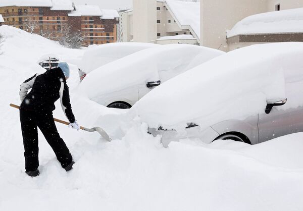 Женщина убирает снег возле своей машины в Сен-Шаффри, Франция - Sputnik Молдова