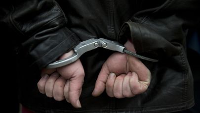 Мужчина в наручниках после задержания полицией 
