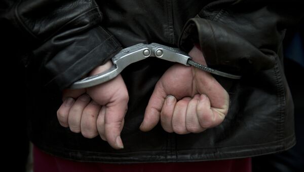 Мужчина в наручниках после задержания полицией  - Sputnik Молдова